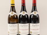 three bottles of wine are lined up on a white surface