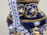 a blue and gold vase with a bow on it