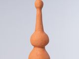 un petit vase orange posé sur une table blanche