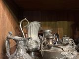 many silver vases on a shelf in a room