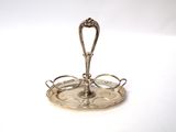 a silver plate with a spoon on it on a white surface