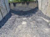 a pile of gravel in the corner of a concrete wall