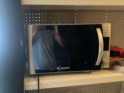 quelqu'un est en train de se prendre en photo dans le miroir d'un micro-ondes