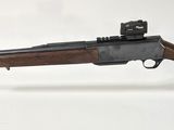 un fusil posé sur un socle en acrylique transparent, sur fond blanc