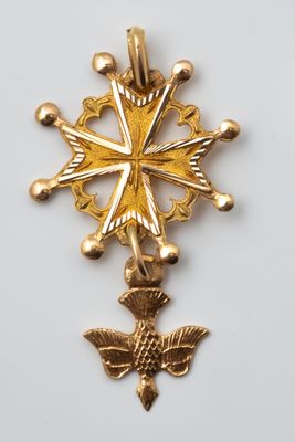 a close up of a gold cross on a white surface