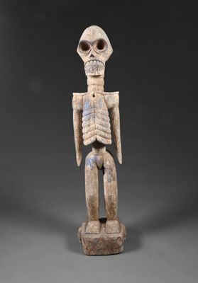 une figurine en bois représentant un squelette avec une grosse tête et des bras