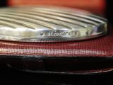 a silver plate sitting on top of a red leather case