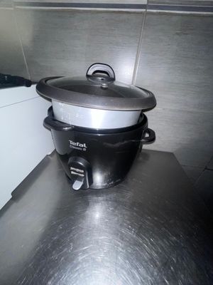 une mijoteuse noire et argentée posée sur le plan de travail de la cuisine