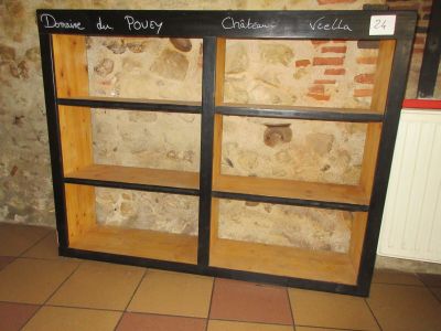 une étagère en bois sur laquelle est posée une pancarte, devant un mur de briques