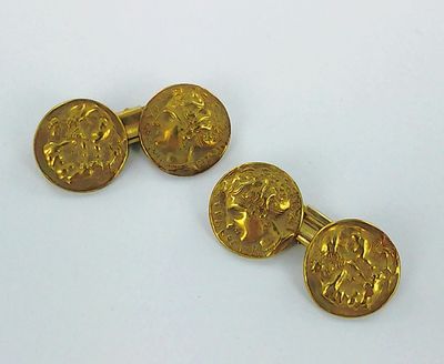 deux paires de boutons de manchette en or posés sur un fond blanc