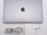 an apple laptop computer sitting on top of a table next to a charger