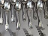 a lot of silver spoons and forks on the table