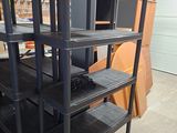 a black shelf that has a bunch of computer monitors on top of it