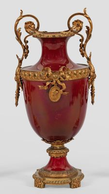 a large red vase with gold decoration on it