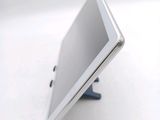 a tablet computer sitting on a stand on a white surface