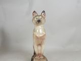 statue of a cat sitting on top of a wooden block