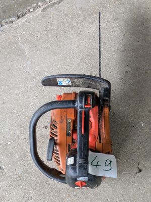 une tronçonneuse posée sur le trottoir, avec une étiquette de prix accrochée dessus