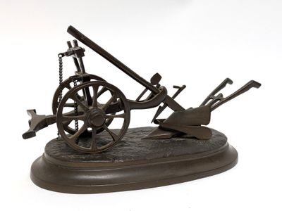 bronze model of a cannon and a wheel on a stand