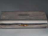 a silver box with a gold decoration on top of it