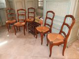 six wooden chairs in a room with marble flooring