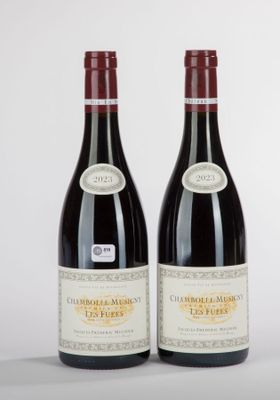 two bottles of red wine sitting next to each other on a table