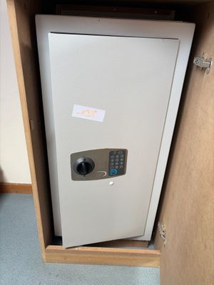 a small safe box in the corner of a cabinet
