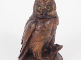 an owl statue sitting on top of a wooden base