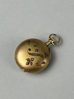 a gold pocket watch with diamonds on it on a white surface
