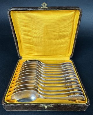 six silver spoons in a case with a yellow lining