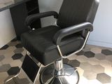 une chaise noire qui se trouve dans une pièce au sol en damier
