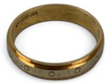 a close up of a gold ring on a white surface