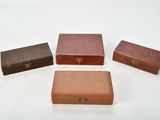 three small wooden boxes are lined up on a white surface