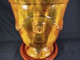 a large yellow vase with a lion head on it