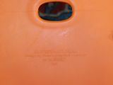 an orange plastic container with a hole in the middle of it