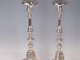 a pair of silver candlesticks on a white background