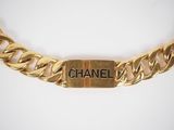 a close up of a gold chain with the word chanel on it