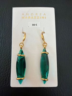 une paire de boucles d'oreilles vertes posées sur une carte blanche