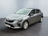 Une voiture argentée est garée dans une pièce au sol noir.