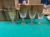 trois verres à vin vides posés sur une table, à côté d'une boîte contenant des verres à vin vides