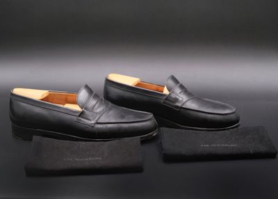 une paire de mocassins noirs posée sur une boîte noire