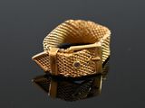 a close up of a gold bracelet on a black surface