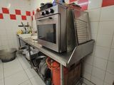 une cuisine équipée d'une cuisinière et d'un micro-ondes posés sur le plan de travail