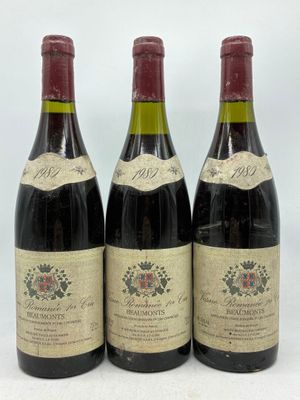 trois bouteilles de vin sont alignées sur une surface blanche