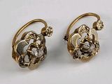 deux paires de boucles d'oreilles posées sur une surface blanche