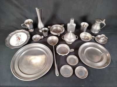 a lot of silverware on a table with a clock in the background