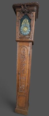 une horloge de parquet en bois posée sur une surface grise