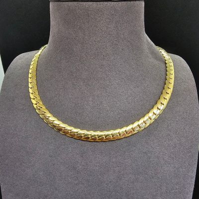 un collier en or sur un mannequin dans une vitrine de magasin