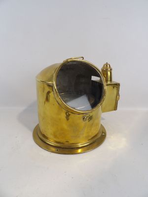 une image représentant une lampe plaquée laiton posée sur une surface blanche