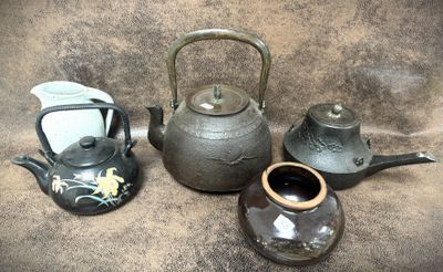 trois théières et une théière posées sur une table