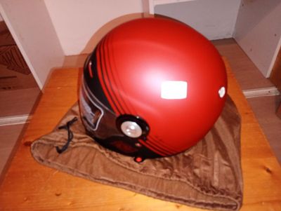 un casque rouge posé sur un tissu marron